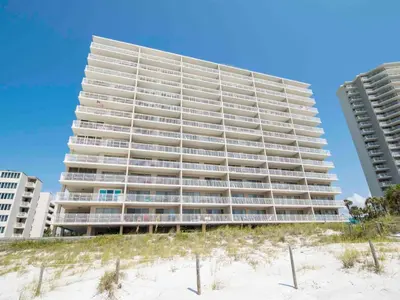 a tall building on the beach next to the sand at Dunes of Panama #B203 in Panama City Beach