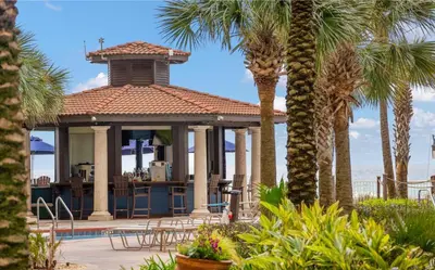 a house with a gazebo with palm trees at Beachfront Retreat! Spacious Resort Condo with Great Views! by Dolce Vita Getaways PCB! in Panama City Beach