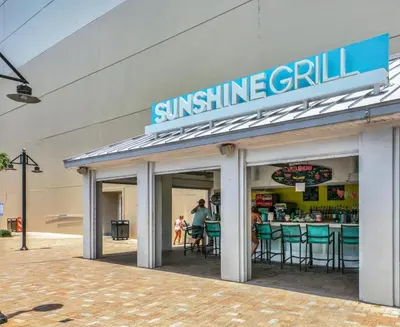 a sun shine grill sign on the side of a building at Oceanview Family Friendly Resort Low Floor Condo! Steps 2 Beach! by Dolce Vita Getaways PCB in Panama City Beach
