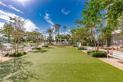 a park with benches and grass and trees at Oceanview Family Friendly Resort Low Floor Condo! Steps 2 Beach! by Dolce Vita Getaways PCB in Panama City Beach