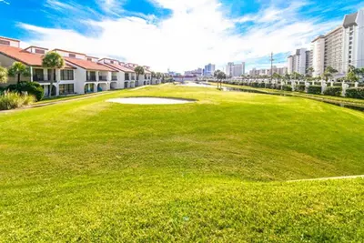 a golf course with a green field and buildings at Edgewater Golf Villa 3101 in Panama City Beach