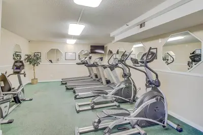 a gym with several treadmills and elliptical machines at The Summit 431 in Panama City Beach