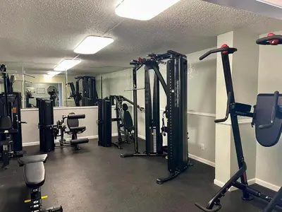 a gym with several treadmills and machines in a room at The Summit 431 in Panama City Beach
