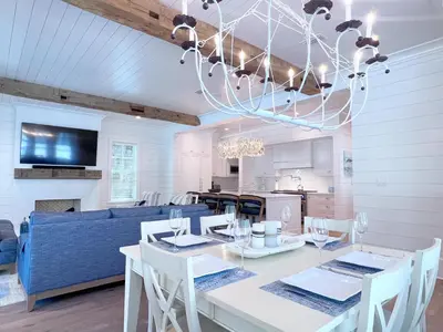 a dining room with a table and a blue couch at Watersound 13 - Hosted by Top Villas in Watersound Beach