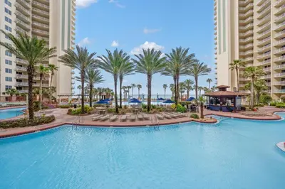 a swimming pool at a resort with palm trees and buildings at Shores Of Panama #1826 in Panama City Beach