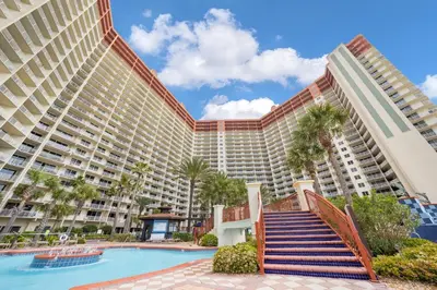a large resort building with a swimming pool and palm trees at Shores Of Panama #1830 in Panama City Beach