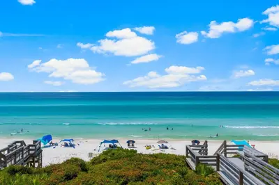 a beach with people in the water and umbrellas at Seamist #8 in Seacrest