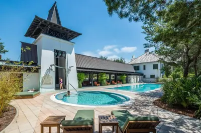 a swimming pool in front of a building at Lola's Carriage House in Rosemary Beach