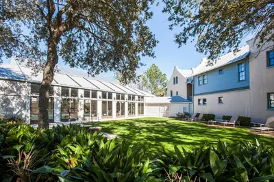 an exterior view of a building with a green yard at Benoit Cottage in Rosemary Beach
