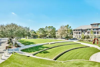 a park with green grass and a building at Thyme & Place in Rosemary Beach