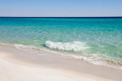 a wave breaking on a beach near the ocean at Beachfront Bliss Awaits: 2-Bed, 2-Bath Condo at Sterling Reef - Sleeps 6! in Panama City Beach