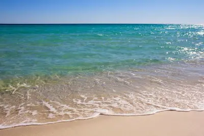 a sandy beach with the ocean in the background at Escape to Sand Dollar Holler: Coastal Retreat, 3 Beds, 25 Baths, Sleeps 10! in Panama City Beach