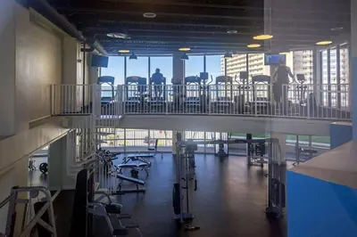 a gym with chairs and tables in a building at Laketown Wharf #1531 by Nautical Properties in Panama City Beach