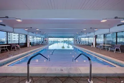 a swimming pool in a building with tables and chairs at Beautiful Gulf and Lake views from Pinnacle Port A-935! in Panama City Beach