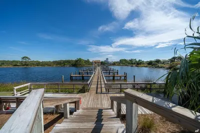 a wooden bridge over a lake with wooden benches at Beautiful Beach Front Paradise at Pinnacle Port B2-608! in Panama City Beach