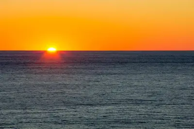 an orange and yellow sunset over the ocean at Emerald Beach Resort 234 | Roo’s Rendezvous in Panama City Beach