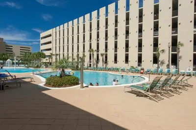 a large building with a swimming pool in front of a building at Emerald Beach Resort 1431 | Tucker’s Tondo in Panama City Beach