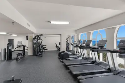 a gym with rows of treadmills and machines at 1005 Calypso Direct Ocean Front Master on the Gulf in Panama City Beach