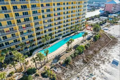 an aerial view of a resort with a pool and palm trees at Calypso 1007E in Panama City Beach