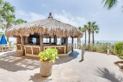 a hut with a straw roof on the beach at Calypso 1007E in Panama City Beach