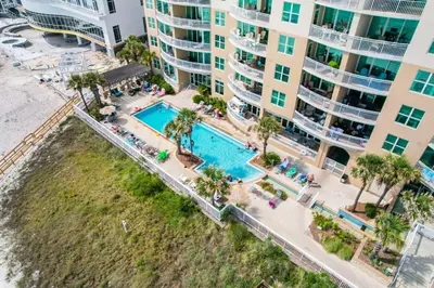 an aerial view of a swimming pool in front of a building at Aqua 410 in Panama City Beach