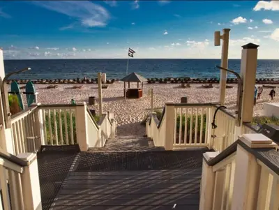 a wooden ramp leading to a beach with the ocean at Calypso 206W Low Floor West Tower No elevators needed in Panama City Beach