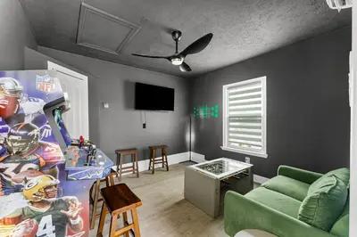 a living room with a green couch and a tv at Spring Break! Heated Pool, Walk 2 Beach, Sleeps 11 in Panama City Beach