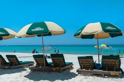 a group of chairs and umbrellas on a beach at Twin Palms 702 in Panama City Beach