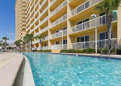 a swimming pool in front of a building at Calypso 1206 West Direct Gulf Front Custom Walk In Shower in Panama City Beach