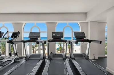 a gym with a row of treadmills at Calypso 1801W Corner Unit Incredible wrap around Balcony in Panama City Beach