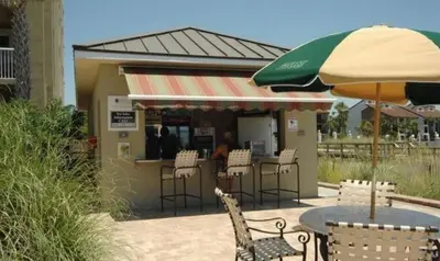 a restaurant with a table and chairs and an umbrella at Grand Panama 604 in Panama City Beach