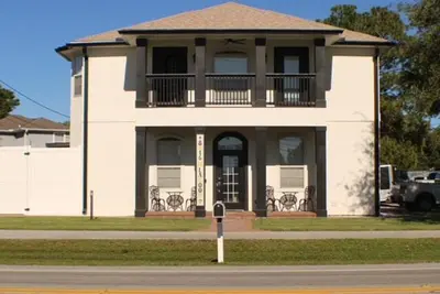 a large white house with a balcony on a street at Vibrant NewOrleans style retreat in Panama City Beach