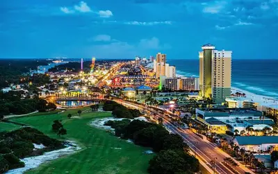 a view of a city with a beach at night at Stunning 4BD Jacuzzi - 4 Min To Beach Panama City in Panama City Beach
