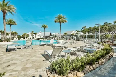 a pool at a resort with chairs and palm trees at Feeling Tip Sea Golf Cart Bikes Prominence in Watersound Beach