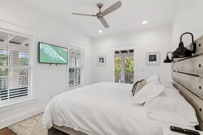 a white bedroom with a bed and a ceiling fan at 30A Caspian Blue Cottage in Seacrest
