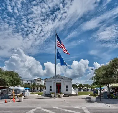 an american flag on a pole in front of a building at The Story House Walk To Beach Pet Friendly in Seacrest
