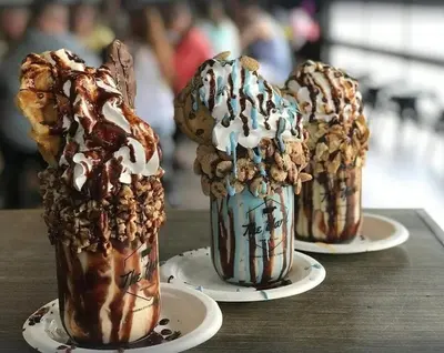three chocolate milkshakes on plates on a table at Calypso 1204E in Panama City Beach