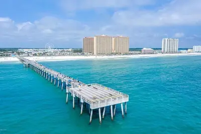 a pier in the ocean with a beach and buildings at Calypso 1401E in Panama City Beach