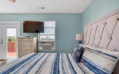 a bedroom with a large bed with a large headboard at Sand Dollar by Emerald Coast Retreats in Panama City Beach