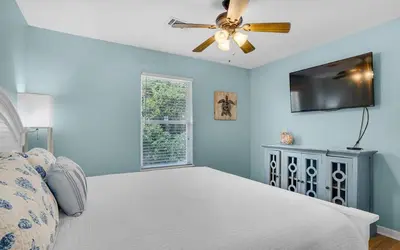 a bedroom with a bed and a ceiling fan at Sand Dollar by Emerald Coast Retreats in Panama City Beach