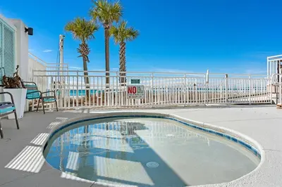 a swimming pool with palm trees and a fence at Watercrest 1405 - Crystal-Gulf Overlook - Sleeps 8 in Panama City Beach