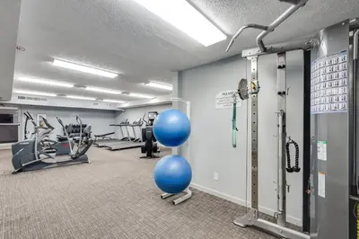 a gym with cardio equipment and blue balls in a room at Watercrest 401 Amazing wrap around balcony in Panama City Beach