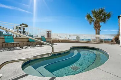 a small swimming pool with chairs and a palm tree at Gulf Peak Retreat - Watercrest 2 BR 2 BA - Sleeps in Panama City Beach