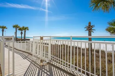 a white fence on the beach with palm trees at Gulf Peak Retreat - Watercrest 2 BR 2 BA - Sleeps in Panama City Beach