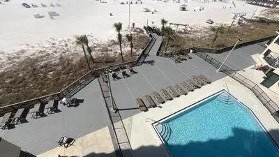 an overhead view of a swimming pool with chairs and a beach at Sunbird Resort 8th Floor Stunning Beach View - by Sunbird Rentals in Panama City Beach