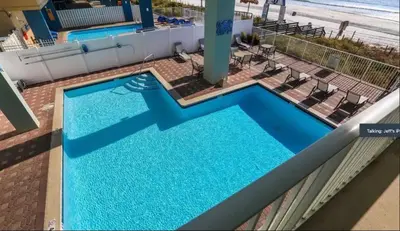 an overhead view of a swimming pool with the beach at Gulf-Front Corner Unit! Stunning Coastline Views! by Dolce Vita Getaways PCB in Panama City Beach