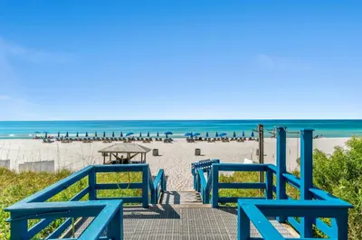 a blue stairway to the beach with chairs and tables at Seychelles Resort by Panhandle Getaways in Panama City Beach