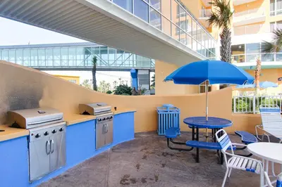 a patio with a table and chairs and an umbrella at Splash Beach Resort by Panhandle Getaways in Panama City Beach