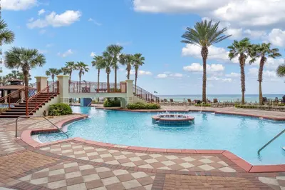 a large swimming pool with palm trees and a boat at Shores Of Panama #0924 in Panama City Beach