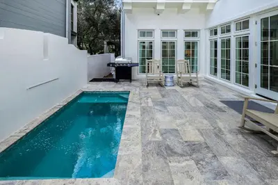 a swimming pool in the middle of a patio at Harp's Haven Main House in Inlet Beach